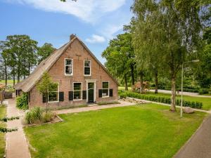 an old brick house with a grass yard at De Boerstee in Ruinerwold