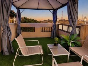 a balcony with chairs and a table and an umbrella at Olympus B&B in Mitzpe Ramon
