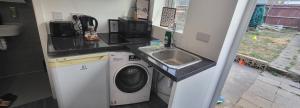 a small kitchen with a washing machine and a sink at lovely Studio Flat in The Hyde +9 photos