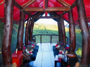 a room with a red roof with people sitting on couches at Le Nid Du Dragon Rouge in Courniou