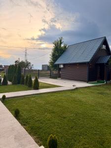 a building with a grassy yard next to a house at Taca House - Airport apartman in Surčin +30 photos