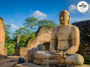a statue of a man sitting in a meditation pose at Sanctuary Cove Guest House in Polonnaruwa