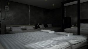 a bedroom with a large bed with white sheets and pillows at the loft residence in Ban Plai Khlong Bang Noi