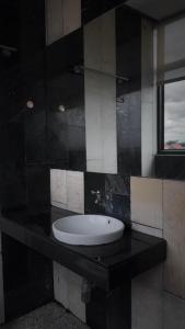 a bathroom with a black counter with a sink at the loft residence in Ban Plai Khlong Bang Noi