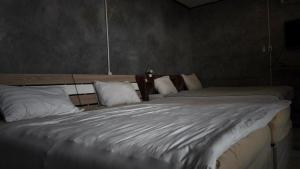 a bedroom with two beds with white sheets and pillows at the loft residence in Ban Plai Khlong Bang Noi