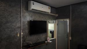 a room with a flat screen tv on a wall at the loft residence in Ban Plai Khlong Bang Noi