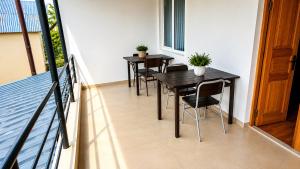 a balcony with three tables and chairs on a balcony at Tuz House R6 in Bakuriani