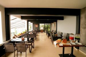 a dining room with tables and chairs in a restaurant at Veu Munnar Retreat - Valley View Rooms in Munnar