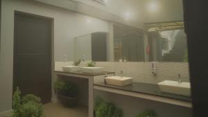 a bathroom with three sinks and two mirrors at Veu Munnar Retreat - Valley View Rooms in Munnar +102 photos
