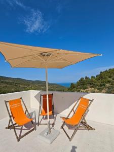 two chairs and an umbrella on a patio at ARTEAMARE in Vignanotica in Mattinata