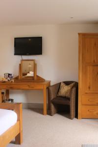 a room with a desk and a chair and a mirror at The Selsey Arms in West Dean