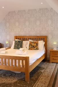 a bedroom with a wooden bed with white sheets and pillows at The Selsey Arms in West Dean