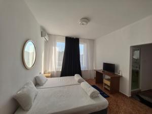 a bedroom with a bed and a desk and a mirror at Стаи за гости Ескейп in Isperikh