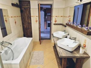 a bathroom with two sinks and a bath tub at Chalupa u dvou žab in Janov +13 photos