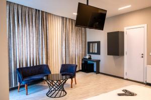 a room with two chairs and a table and a television at zoom hotels in Eskiömerler