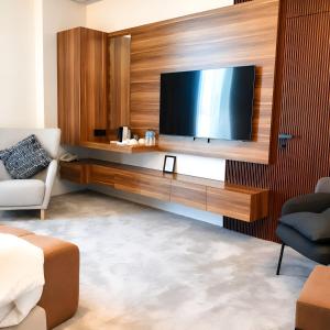 a living room with a flat screen tv on a wall at Bloom Hotel-Kuwait in Kuwait