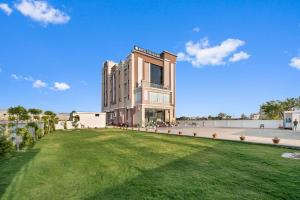 a building with a green lawn in front of it at Hotel The Balram in Ayodhya