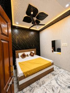 a bedroom with a bed with a ceiling fan at Lakshman Guest House Ayodhya in Jāmb