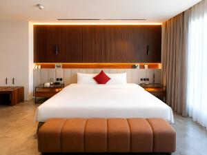 a bedroom with a large white bed with red pillows at Bloom Hotel-Kuwait in Kuwait