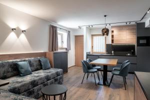 a living room with a couch and a table at Vidor Resort in Pozza di Fassa