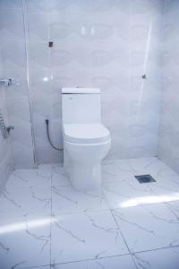 a white bathroom with a toilet and a shower at Wete View Hotel in Wete +19 photos