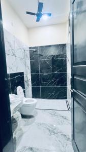 a bathroom with a toilet and a ceiling fan at Mannat Villa Homestay in Rāmnagar
