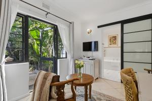 a living room with a table and chairs and a window at Paradiso Guesthouse & Self-catering Cottage in Cape Town