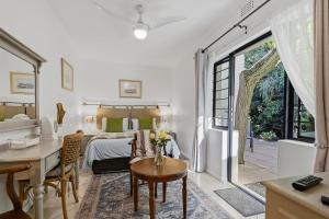 a bedroom with a bed and a desk and a table at Paradiso Guesthouse & Self-catering Cottage in Cape Town +36 photos