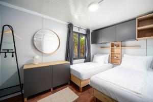 two beds in a small room with a mirror at Mobile Homes Vrata Krke in Lozovac +29 photos