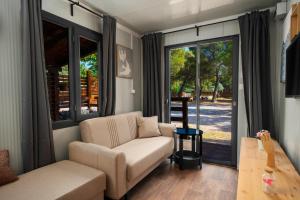 a living room with a couch and a sliding glass door at Mobile Homes Vrata Krke in Lozovac