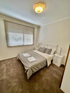 a bedroom with a large bed and a window at Jalynn homestay in Glen Waverley +6 photos