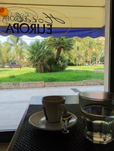 a coffee cup on a table in front of a window at Hotel Europa in Arma di Taggia +14 photos