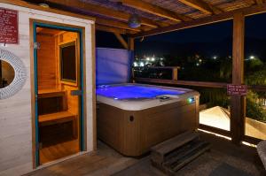 a jacuzzi tub on a deck at night at וילה מקסים בחוסן - וילה מהממת עם בריכה, ג'קוזי וסאונה in H̱osen