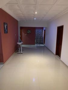 a large room with a white floor and red walls at FREDJACKSAIR BNb in Koforidua