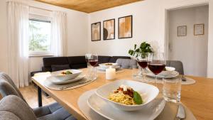 a table with a bowl of pasta and glasses of wine at Wohnung für 4 Personen, 2 Schlafzimmer, Küche, Wlan in Großostheim