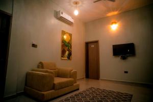 a living room with a chair and a flat screen tv at Wete View Hotel in Wete