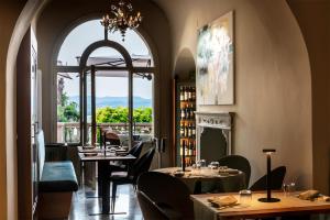 a restaurant with tables and chairs and a window at Garden Palace Hotel in Castiglione del Lago