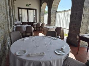 a dining room with tables and chairs with white table cloth at El Linar in Burgohondo