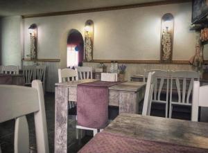 a restaurant with white tables and white chairs and a room at Стаи за гости Дворъ in Varna City