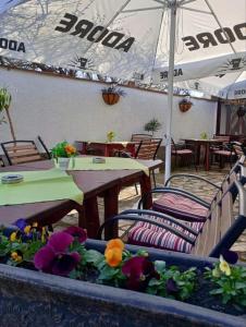 a restaurant with tables and chairs and tables and umbrellas at Стаи за гости Дворъ in Varna City