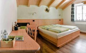 Schlafzimmer mit einem Bett und einem Holztisch in der Unterkunft B&B 3 Cuori in Predazzo