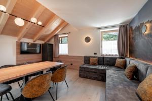 a living room with a couch and a table at Vidor Resort in Pozza di Fassa