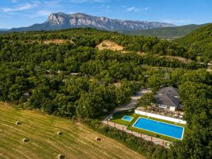 an aerial view of a farm with a swimming pool and mountains at HolaCamp Aínsa in Aínsa