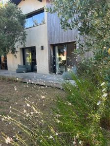 a house with glass windows and a yard at Les mimosas in Tosse