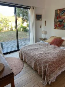 a bedroom with a bed and a large sliding glass door at Les mimosas in Tosse