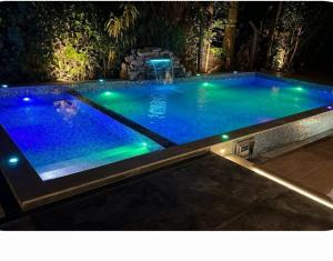 a large swimming pool with lights in a backyard at night at Diamond Resorts in Udawalawe
