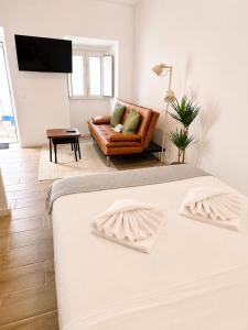 a white bedroom with a bed and a couch at Casa Nº9 - Vila d'Óbidos in Óbidos