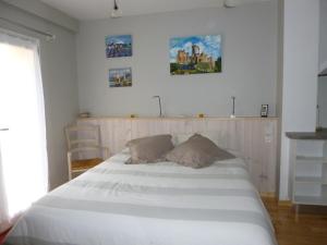 FumelにあるAux Blanches Pierresのベッドルーム1室(大きな白いベッド1台、枕2つ付)