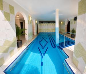a swimming pool in a hotel with blue tiles at Dom Wczasowy GLOBUS in Ustroń