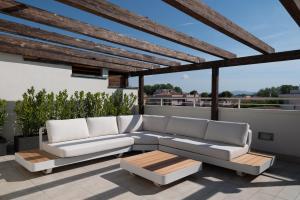 a patio with a couch and a coffee table at Fill's Luxury Design Apartments 100m from the Beach in Rimini
